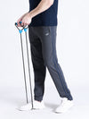 Man wearing a grey solid slim fit charcoal grey track pant on a light gray background