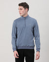 Man wearing a blue vintage blue solid cotton sweatshirt on a light gray background