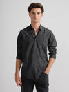 Man wearing a grey grey monochrome checks polished attire comfort fit shirts on a light gray background