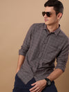 Man wearing a casual maroon checked full sleeve 100% cotton shirt with casual styling on a gray background