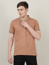 Man wearing a brown khaki brown printed polo t shirt with casual styling on a gray background
