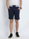 Man wearing a blue blue solid slim fit interlock track shorts with casual styling on a gray background