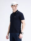 Man wearing a navy casual navy solid polo t shirt with pocket on a light gray background