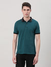 Man wearing a blue printed teal blue polo t shirt with casual styling on a gray background