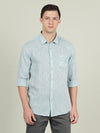 Man wearing a blue blue solid full sleeve linen shirt on a light gray background