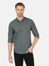 Man wearing a green olive green checked full sleeve shirt on a light gray background
