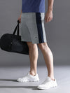 Man wearing a grey solid relax fit grey track shorts on a light gray background