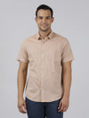 Man wearing a beige beige solid half sleeve 100% cotton shirt with casual styling on a gray background