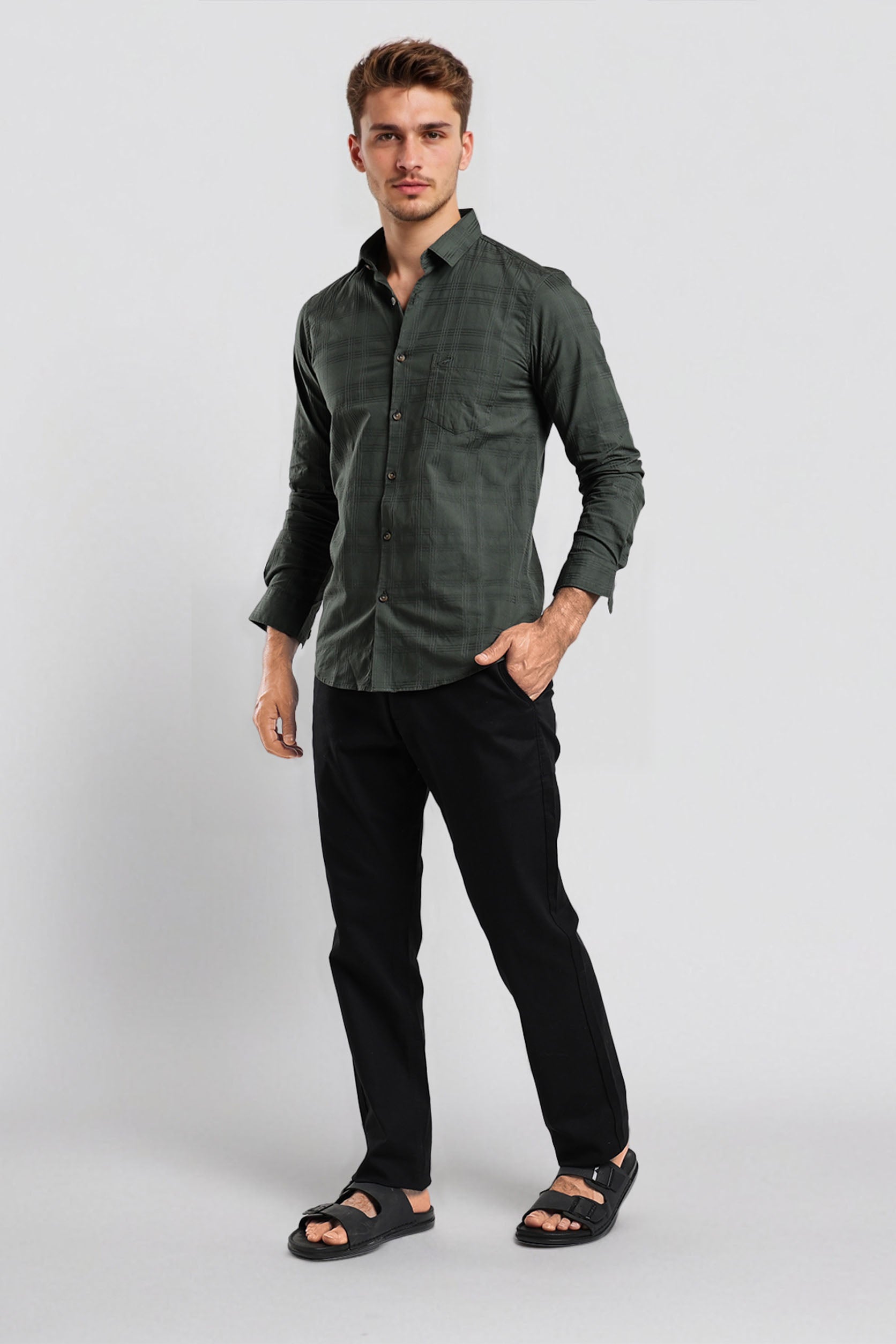 Man wearing a green shirt and black pants on a white background