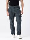 Man wearing a olive garment dyed cargo pant in olive with casual styling on a gray background