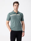 Man wearing a green iceberg green chest print slim fit polo t shirt on a light gray background