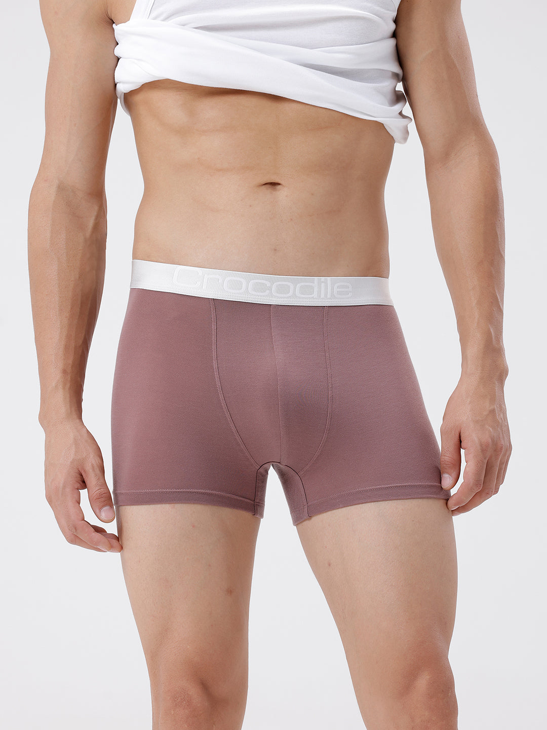 Person wearing mauve boxer briefs with white waistband on a light gray background