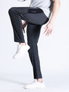 Man wearing a solid slim fit charcoal melange track pant with casual styling on a gray background