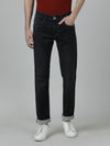 Man wearing a black black solid mid rise slim fit casual jean on a light gray background