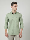 Man wearing a green green solid full sleeve 100% cotton shirt on a light gray background