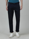 Man wearing a navy solid casual slim fit trouser navy on a light gray background