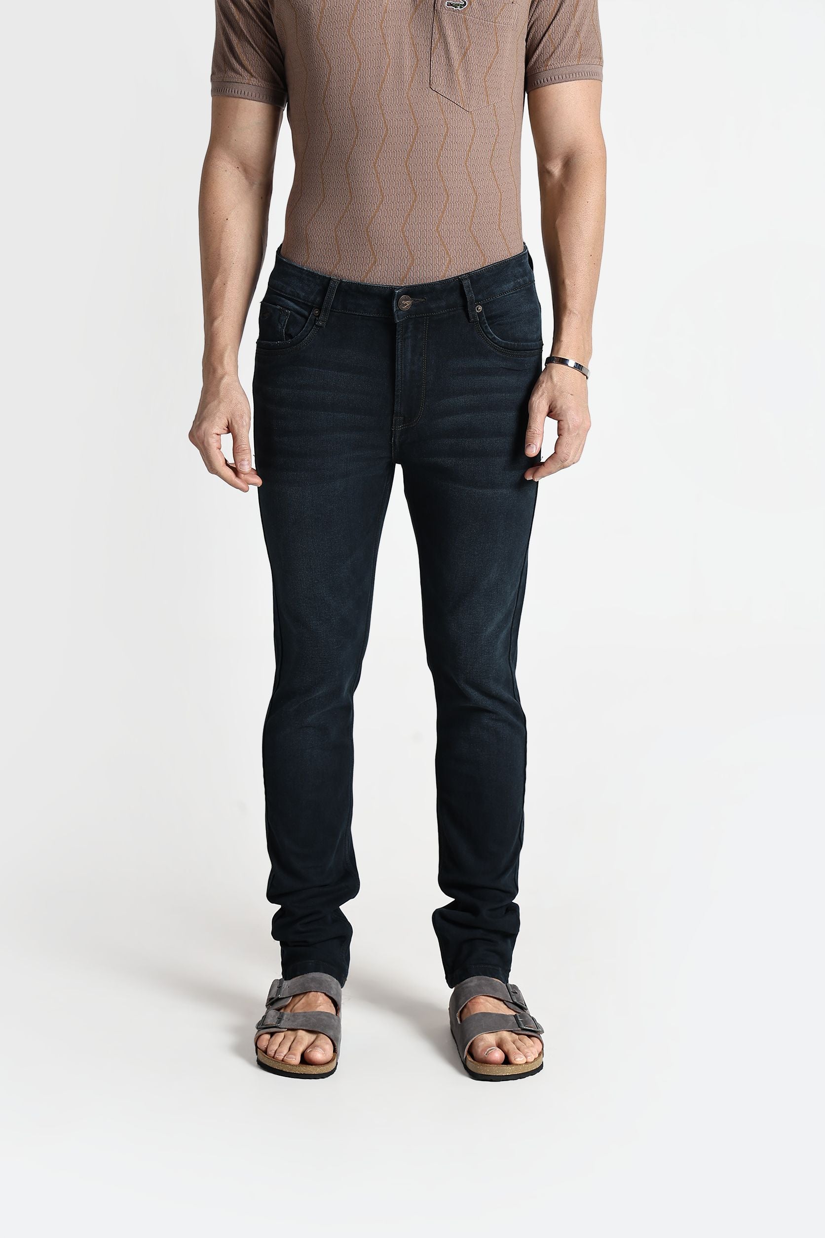 Person wearing dark jeans and a brown shirt on a white background