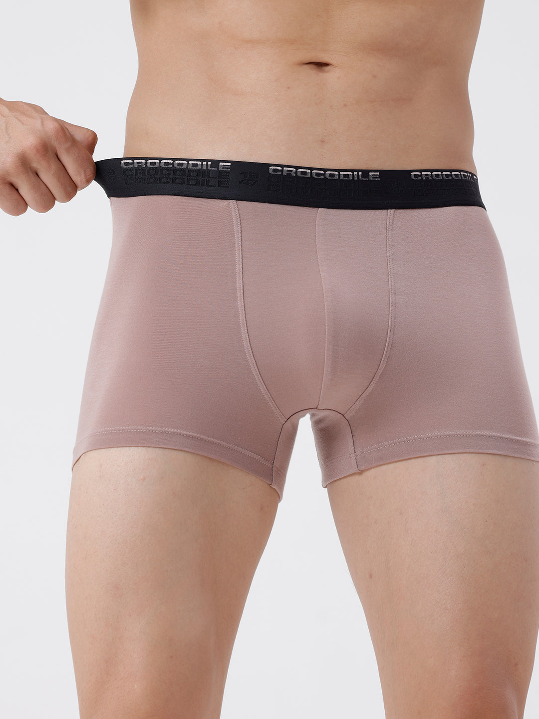 Person wearing pink boxer briefs with a black waistband on a light gray background