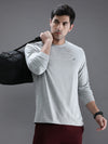 Man wearing a grey casual grey melange solid t shirt on a light gray background