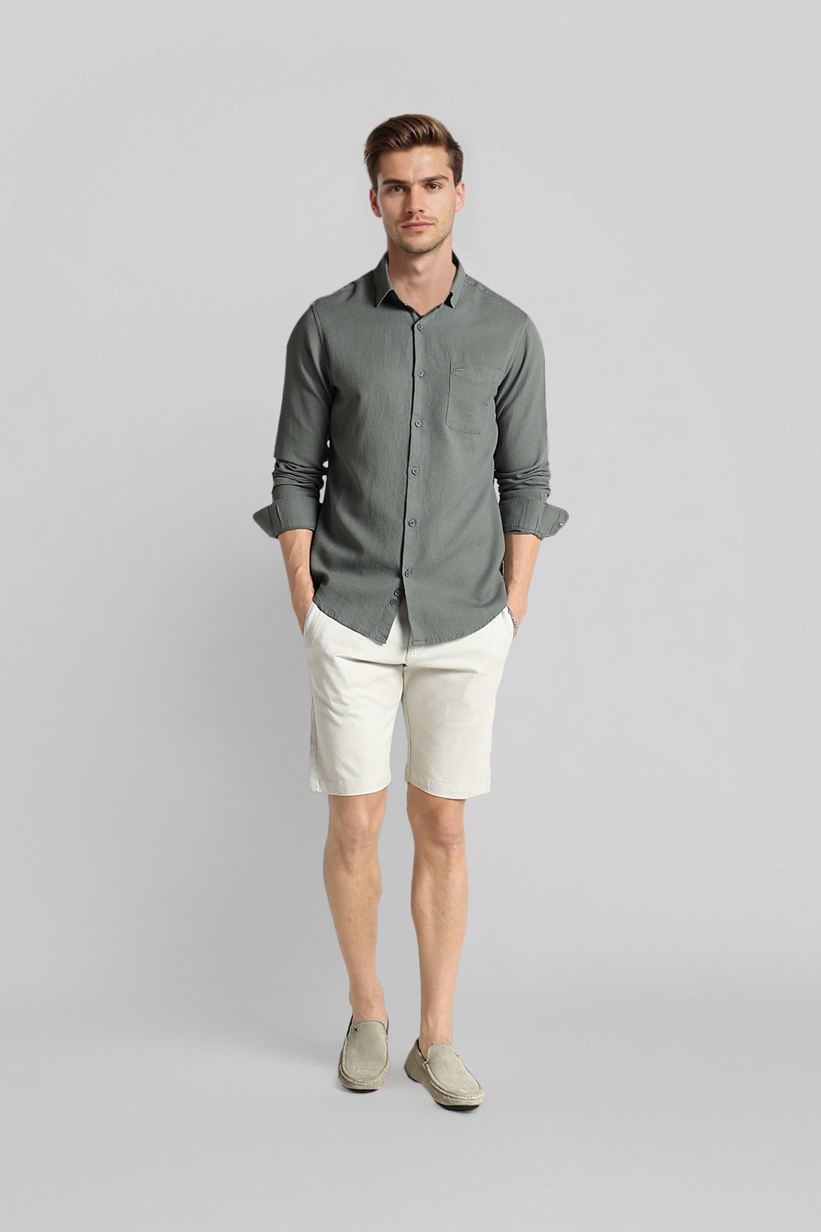 Man wearing a gray shirt and white shorts on a light gray background