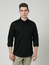 Man wearing a black black solid full sleeve 100% cotton shirt with casual styling on a gray background