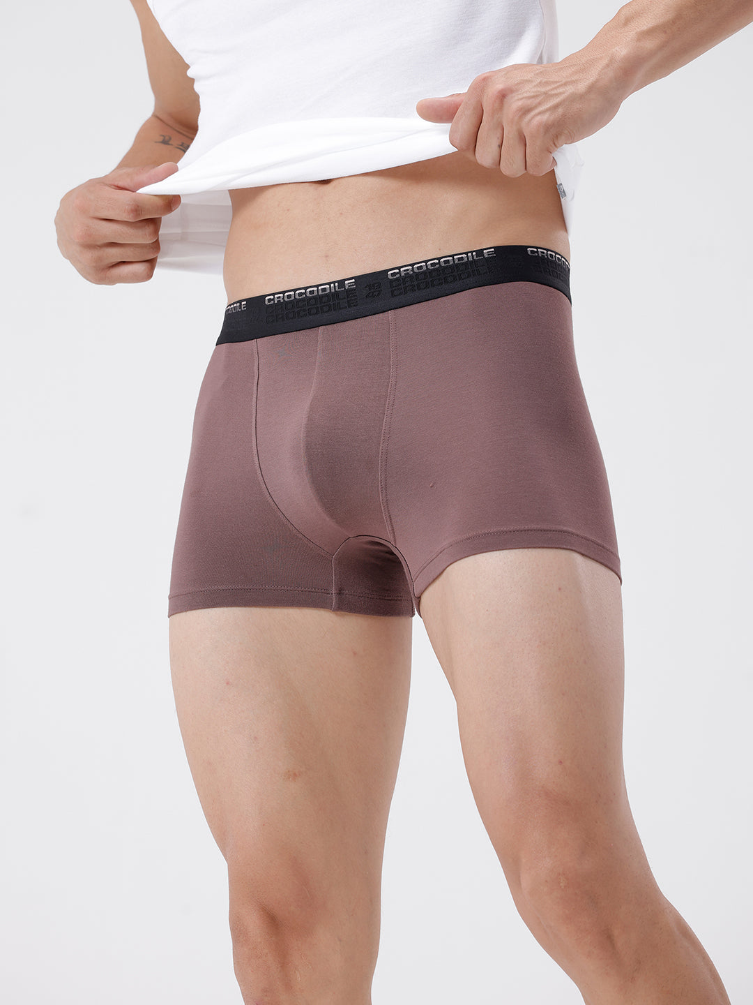 Person wearing brown boxer briefs with a white background