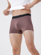 Person wearing brown boxer briefs with a white background