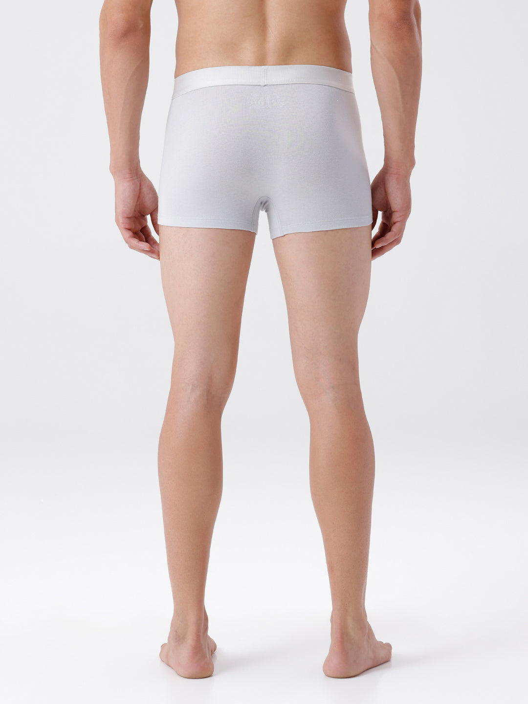 Person wearing a white boxer brief on a plain background