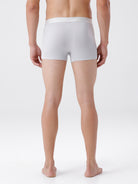 Person wearing a white boxer brief on a plain background