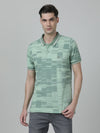 Man wearing a green printed polo t shirt green on a light gray background
