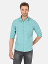 Man wearing a green light green printed full sleeve casual shirt on a light gray background