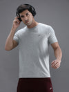 Man wearing a grey grey melange casual solid t shirt on a light gray background