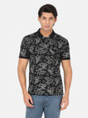 Man wearing a black printed black casual polo t shirt on a light gray background