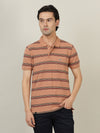 Man wearing a blue tan blue striped polo t shirt on a light gray background