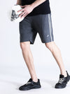 Man wearing a grey solid charcoal grey comfort fit track shorts with casual styling on a gray background