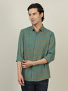Man wearing a green green striped casual full sleeve 100% cotton shirt on a light gray background
