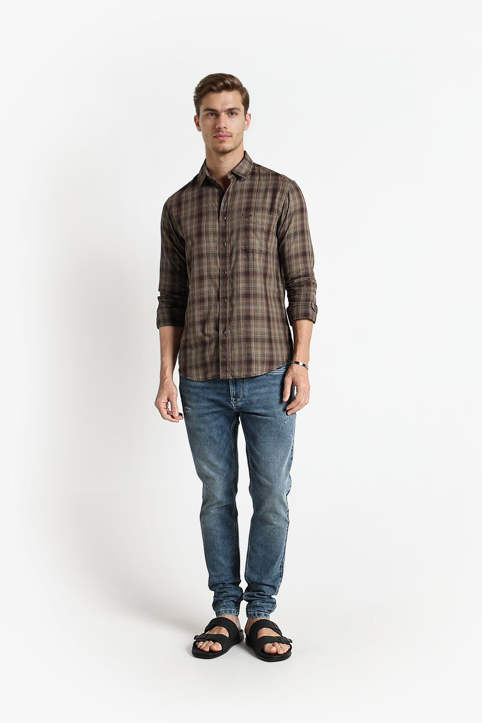 Man wearing a plaid shirt and jeans on a white background