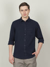 Man wearing a navy navy solid full sleeve casual shirt on a light gray background