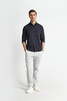 Man wearing a dark shirt and light pants on a white background