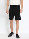 Man wearing a black solid black relax fit track shorts on a light gray background