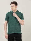 Man wearing a green casual dark green printed polo t shirt with casual styling on a gray background