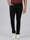 Man wearing a black solid mid rise slim fit black jean on a light gray background