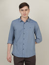 Man wearing a blue casual blue printed full sleeve 100% cotton shirt on a light gray background