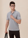 Man wearing a solid half sleeve casual polo t shirt on a light gray background