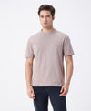 Man wearing a brown light brown printed over sized t shirt with casual styling on a gray background