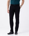 Man wearing a black textured essential chinos in black on a light gray background