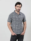 Man wearing a black black printed polo t shirt with casual styling on a gray background