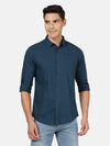Man wearing a blue dark teal blue solid full sleeve 100% cotton shirt with casual styling on a gray background