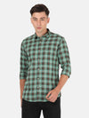 Man wearing a green checked full sleeve green casual shirt with casual styling on a gray background