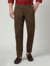 Man wearing a brown trim fit trousers in twill brown on a light gray background